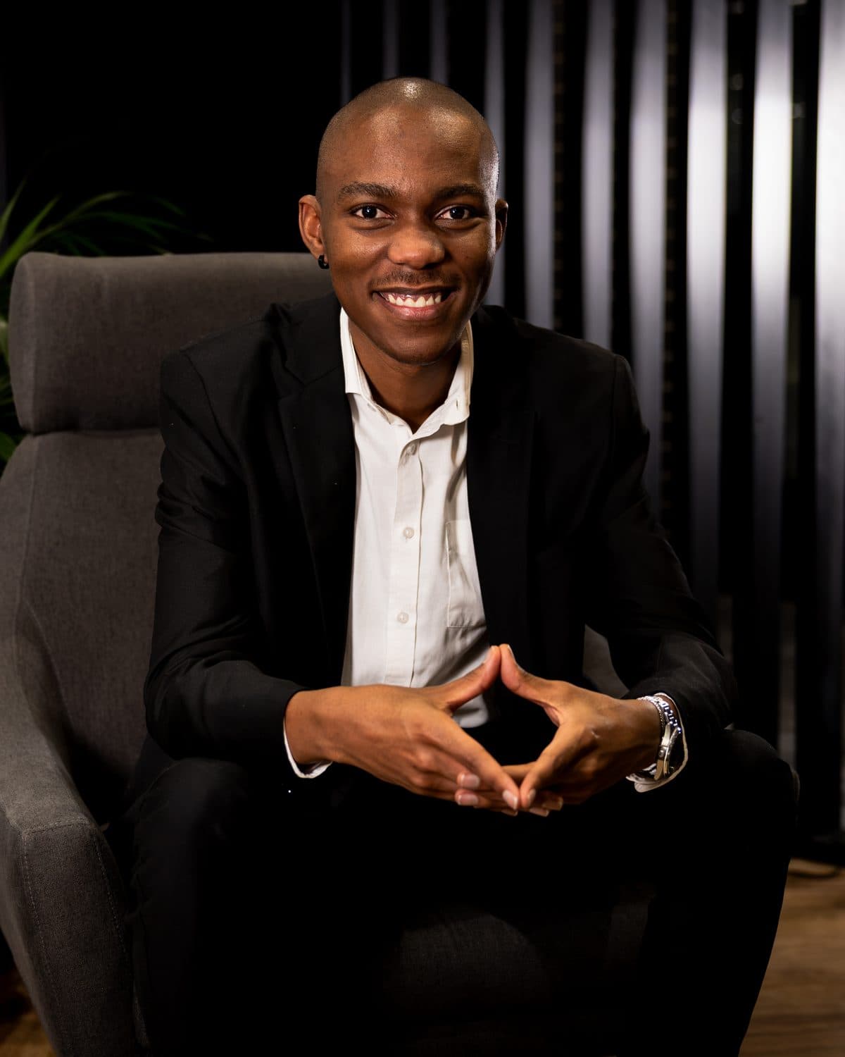 Vuyo Nkadimeng seated, hands together — Senior Full Stack Development Manager at Alpha and founder of Quantyx